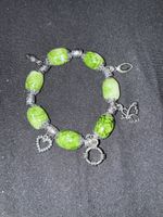 Armband mit grünen Steinen und Anhängern 