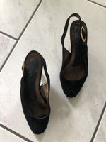 Schwarzer Pumps mit goldigem Absatz und Schnalle