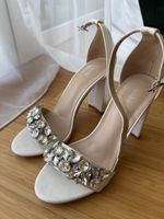 Weiße Brautschuhe, die einmal für ein Fotoshooting getragen 
