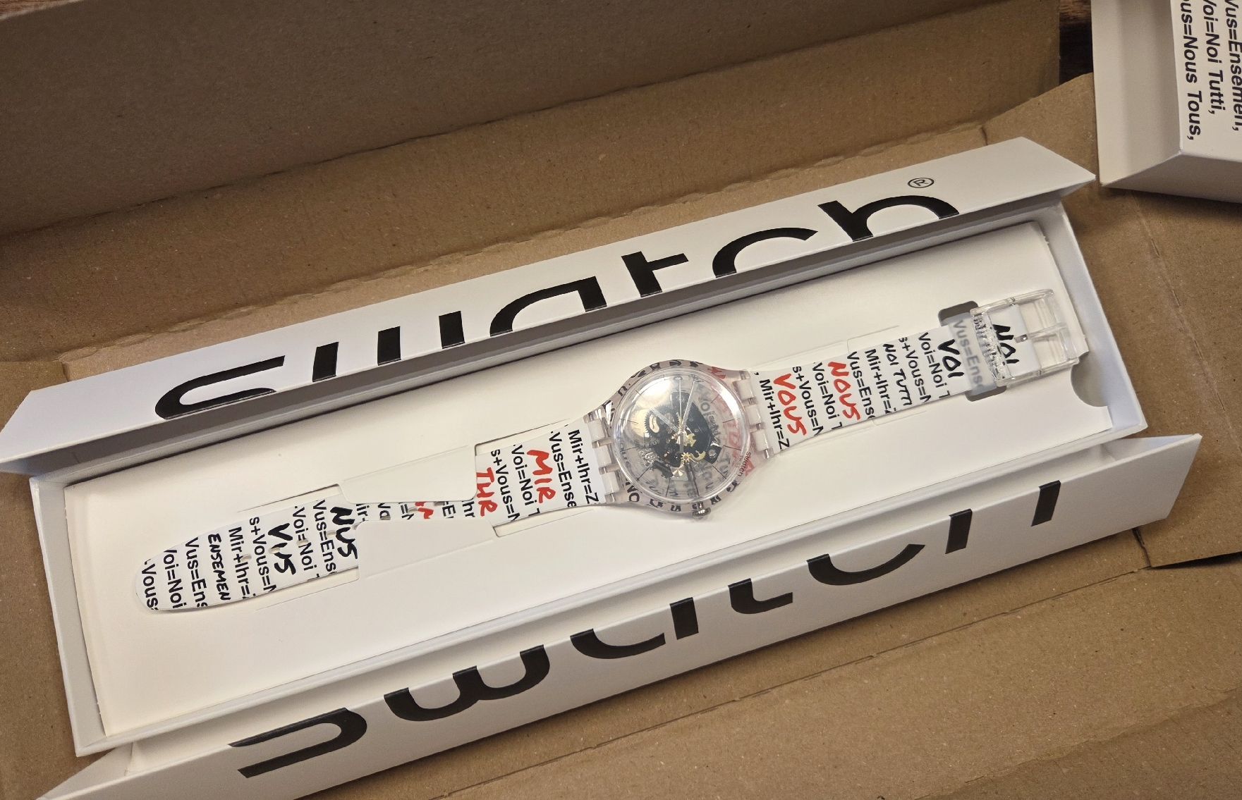 Swatch Orologi: Swatch Aktionärsuhr 2026 – Nuovo e nell'imballaggio originale da Braunau venduto da Brand-Store