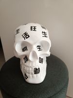 Tête de mort design avec calligraphie asiatique.