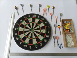 Dartscheiben mit vielen Pfeilen und Zubehör