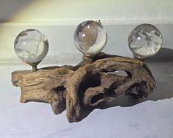 3 klare Bergkristall Kugeln auf Schwemmholz
