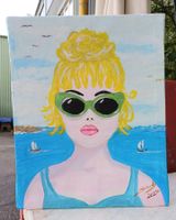 Blonde Frau mit grüne Sonnnenbrille am Meer Blondie am Ozean