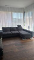 ​Gemütliches Ecksofa in Grau mit Schlaffunktion, Ottomane un