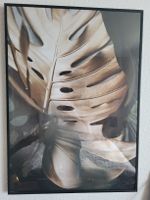 Wandbild Monstera Blatt goldfarben mit Rahmen schwarz