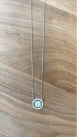 Silver tone necklace with circular pendant