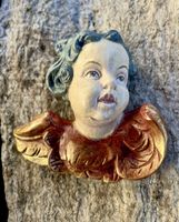 Engelkopf mit goldfarbenen Flügel.