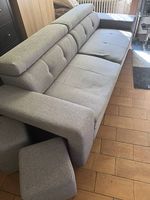 Grand canapé gris convertible en tissu.