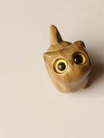 Kleines Holzkätzchen mit gelben Augen