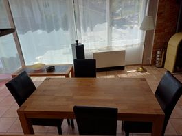 Holztisch mit vier Stühlen.