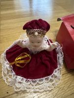 Bambola antica con vestito di velluto rosso e pizzo