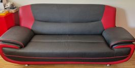 Schwarzes Kunstleder Sofa mit roten Akzenten