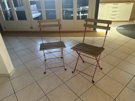 Zwei Klappstühle aus Metall mit Holzfläche