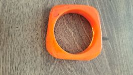 bracelet en résine orange (en bas à gauche)