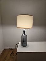 Moderne Tischlampe mit Glasfuss und Stoffschirm
