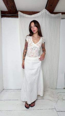 White maxi skirt with lace detailing and asymmetrical hem 