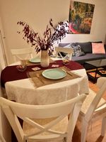White dining table with 4 chairs with cushions