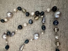 Un magnifique long collier orné de perles grises