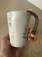 Sammlertasse mit Gitarre-Griff und Noten Design. Neu.