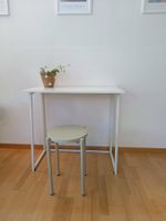 Minimalistischer Klapptisch mit grünem Hocker