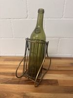 Weinflaschenhalter aus Metall mit grüner Glasflasche