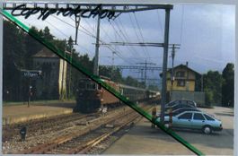 Uttigen Bahnhof. BLS Re 4/4 mit Personenzug. Foto.