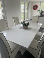 Weißer Tisch mit LED-Leuchten und 6 Stühlen.