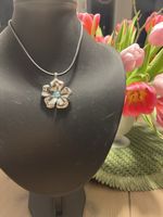 Silberfarbige Blumenkette mit blauem Stein