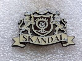 Ansteckpin 186: Skandal