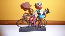 Afrikanischer Velofahrer mit Frau/ Ziege Handarbeit