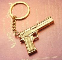 Goldene Pistolen-Schlüsselanhänger - Luxuriöses Accessoire m