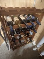 Weinregal aus Holz mit verschiedenen alkoholischen Getränken