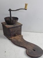 Sehr alte Kaffeemühle mit Sitzbrett aus Holz