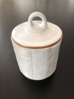 Pot en céramique blanc avec couvercle.