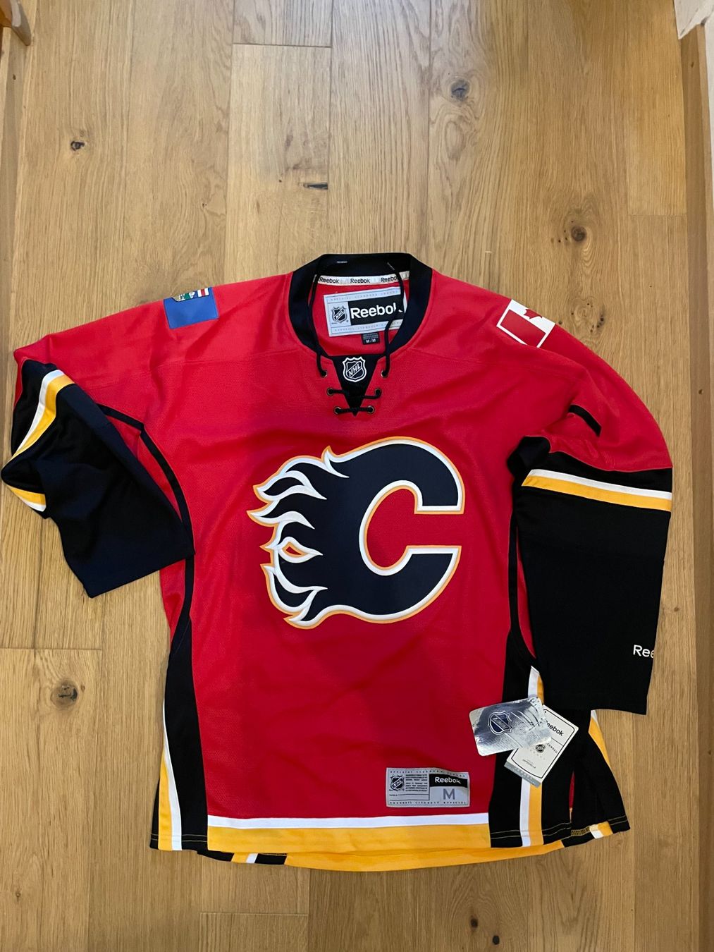 Reebok Leibchen & Hosen: Calgary Flames Reebok Jersey Grösse M – Neu (gemäss Beschreibung) aus Kreuzlingen von deGriGri