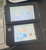Nintendo 3DS XL noire avec chargeur, en très bon état.