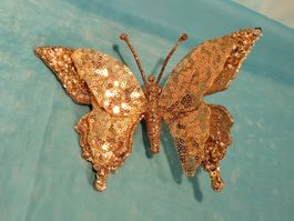 Glitzernder, goldfarbener Schmetterling zum Anstecken