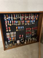Holzvitrine mit Orden und Pokalen