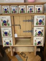 Wandschrank aus Holz mit nostalgischen Keramik Schubladen