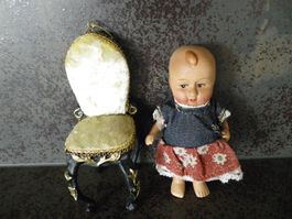 kleine Porzellan-Puppe und Puppenstuhl