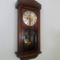 Horloge murale ancienne en bois et en laiton. Fonctionne.