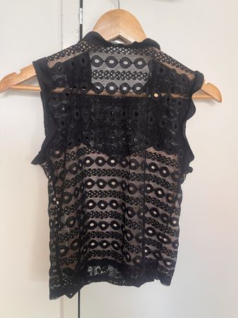 Blusa nera in pizzo traforato con volant – elegante e partic