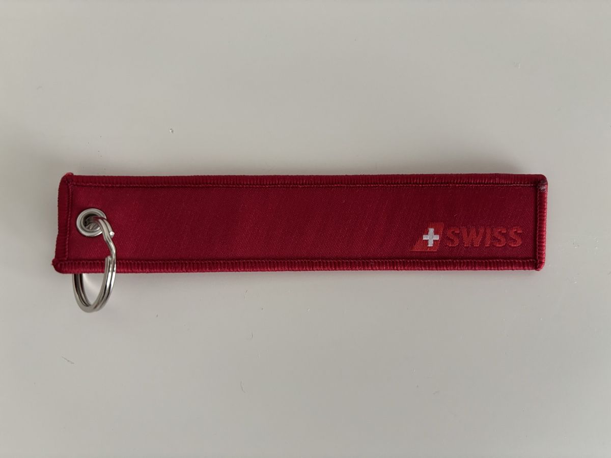 Portachiavi: SWISS "REMOVE BEFORE FLIGHT" Schlüsselanhänger, Rot – Nuovo e nell'imballaggio originale da Bülach venduto da Karuna 1