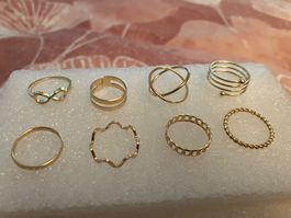 8 goldfarbene zarte Stapelringe, versch. Sujet (s. Foto),neu