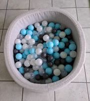 Bällebad mit bunten Kugeln hellblau grau weiss
