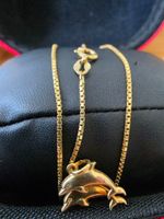 Collier or 18 carat avec pendentif dauphins