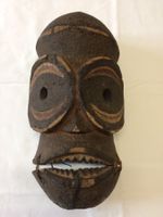 Masque africain tribal en bois sculpté et tanné.