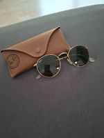 Lunettes de soleil rondes Ray-Ban dorées avec étui.