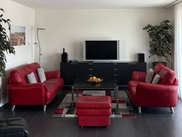 2 Ledersofas mit Hocker und Teppich